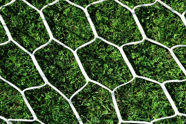 Vit fotboll netto på grönt gräs bakgrund — Stockfoto