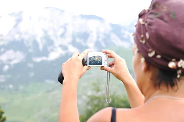 Mujer con cámara en las montañas — Foto de Stock
