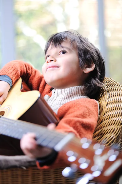 Portrait of young boy playing acoustic guitar at home — Stock Photo, Image