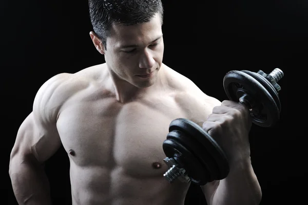 O corpo masculino perfeito - fisiculturista impressionante posando com halteres — Fotografia de Stock