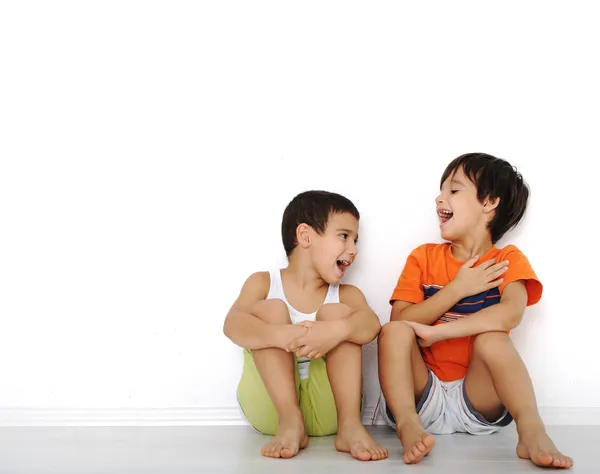 Anak-anak bahagia duduk di rumah, di dalam ruangan — Stok Foto