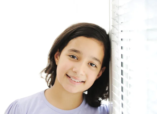 Gelukkig meisje indoor, leunend op het venster — Stockfoto