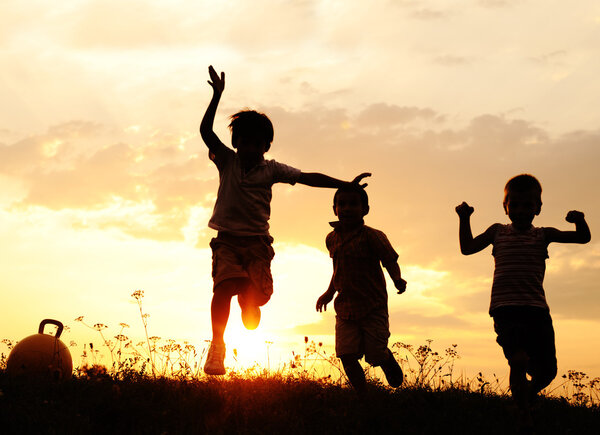 Group of happy children playing on meadow