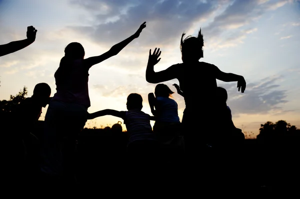 シルエット、幸せな子供のプレー グループ草原、日没、夏 — ストック写真