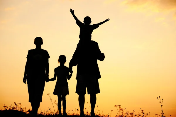 Silhouette, bambini felici con madre e padre, famiglia al tramonto, estate — Foto Stock