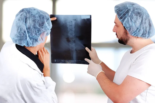 Medical doctors looking at x-ray picture of lungs in hospital — Stock Photo, Image