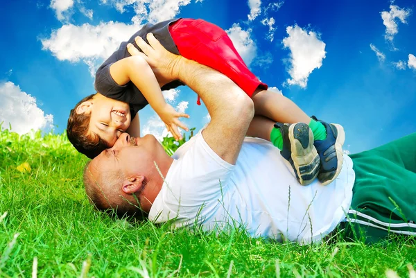 Батько і маленький хлопчик лежать на траві — стокове фото