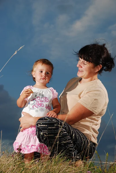 Niña con madre en el prado, antes del atardecer —  Fotos de Stock