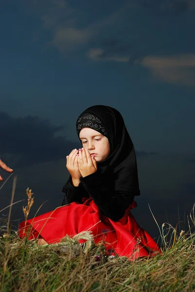 Lilla muslimska flickan på ängen, före solnedgången — Stockfoto