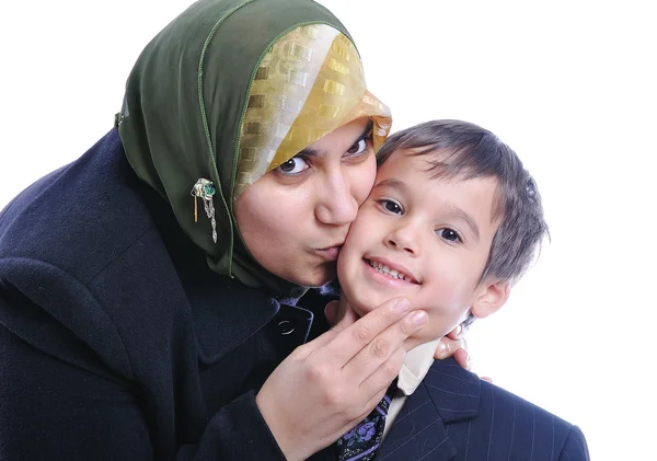 Мусульманская женщина целует своего сына — стоковое фото