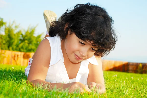 A little cute happy girl on green meadow — Stock Photo, Image