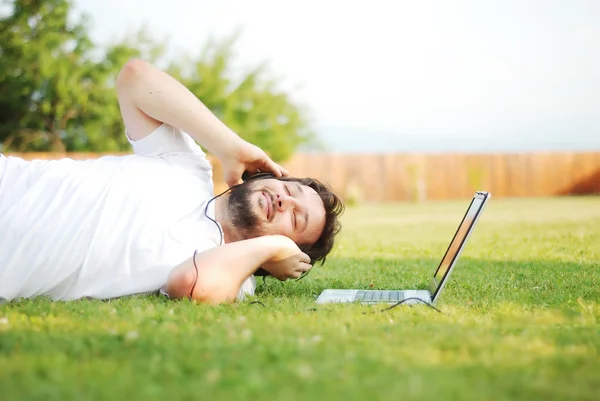 Hombre feliz en el prado escuchando música —  Fotos de Stock