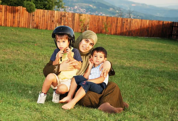 Família muçulmana feliz no prado verde — Fotografia de Stock