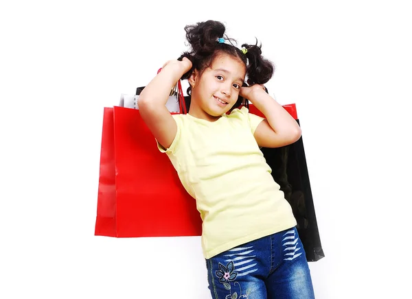 Cute little girl with bags for shopping — Stock Photo, Image