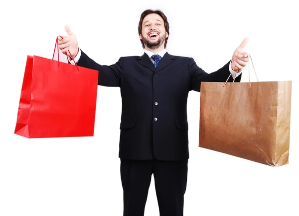 Mladý atraktivní muž nosí oblek a hospodářství nákupní tašky — Stock fotografie