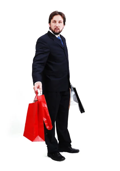 Jovem homem atraente vestindo terno e segurando sacos de compras — Fotografia de Stock