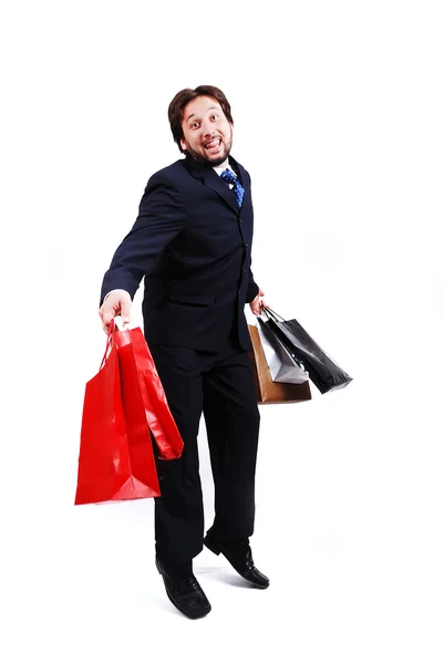 Jovem homem atraente vestindo terno e segurando sacos de compras — Fotografia de Stock
