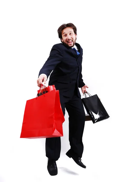 Giovane uomo attraente indossa vestito e tenendo borse della spesa — Foto Stock