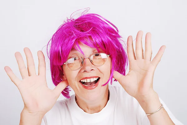 Senior vrouw met roze haar en gezicht gebaar — Stockfoto