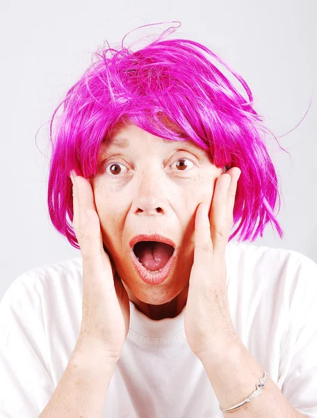 Mujer mayor con cabello rosa y gesto facial — Foto de Stock