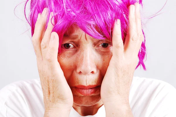 Donna anziana con capelli rosa e gesto facciale — Foto Stock