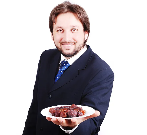 Uomo in giacca e cravatta che tiene le date piatto davanti — Foto Stock