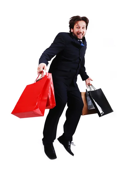 Jovem atraente empresário com sacos de compras saltando — Fotografia de Stock