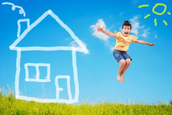 Симпатична дівчина стрибає на зеленому лузі з абстрактним будинком на — стокове фото