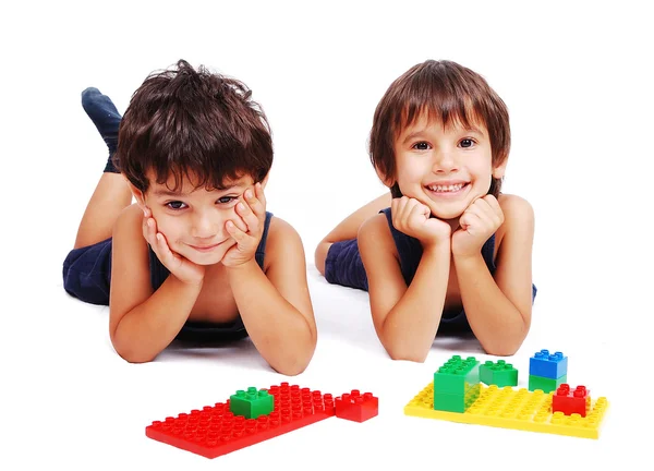 Kinder spielen mit Würfeln im weißen isolierten Raum — Stockfoto