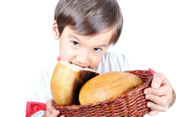 A little cute kid holding bread and biting it — Stock Photo, Image