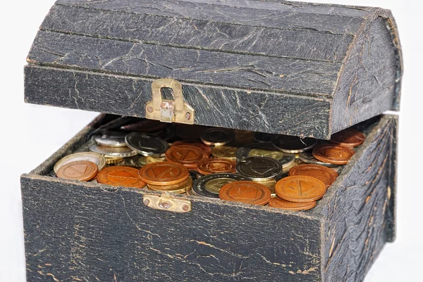 Muitas moedas em um velho peito isolado — Fotografia de Stock