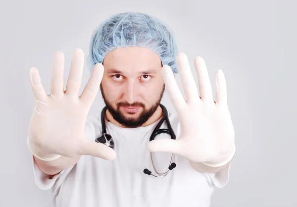 Jovem médico com as mãos na frente e luvas de cirurgia em — Fotografia de Stock
