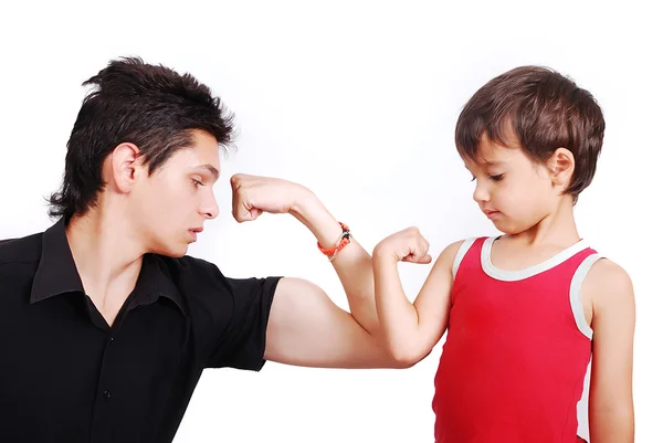 Joven modelo masculino está mostrando músculos a niño pequeño —  Fotos de Stock