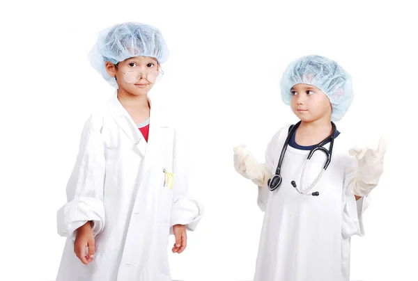 Duas crianças muito fofas em roupas de hospital branco — Fotografia de Stock