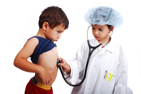 Küçük hoş çocuk doktoru giysileri ile diğer bir oynuyor — Stok fotoğraf