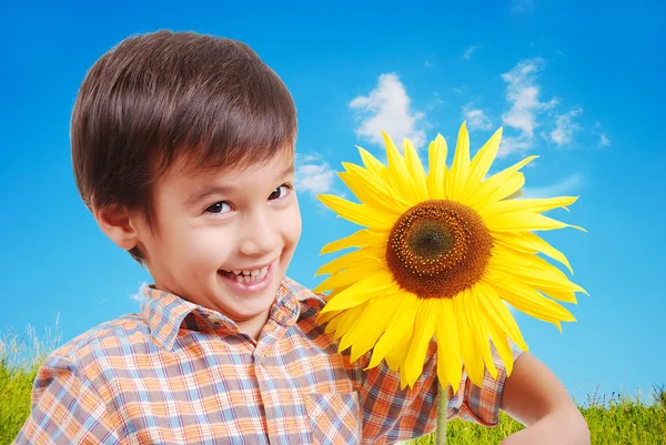 Sehr süßer Junge umarmt Sonnenblume als Freund — Stockfoto