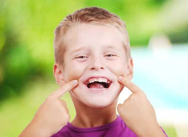 Muy lindo niño divertido con los dedos en la boca — Foto de Stock