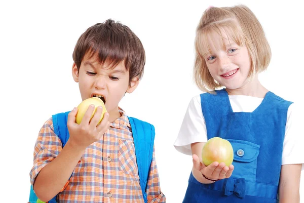 Duas crianças felizes da escola comendo uma maçã — Fotografia de Stock