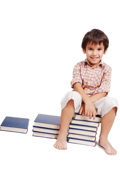 Sehr niedliches weißes Kind, das isoliert auf Büchern sitzt — Stockfoto