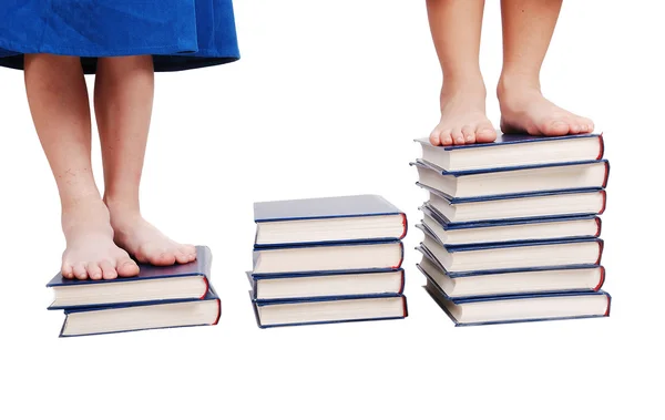 Маленькие ноги, стоящие на книжной лестнице, изолированные — стоковое фото