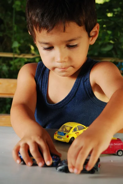 Crianças brincando com carros brinquedos ao ar livre na hora de verão — Fotografia de Stock