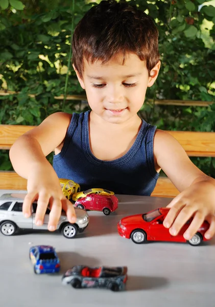 Dzieci bawiące się samochody zabawki na świeżym powietrzu w okresie letnim — Zdjęcie stockowe