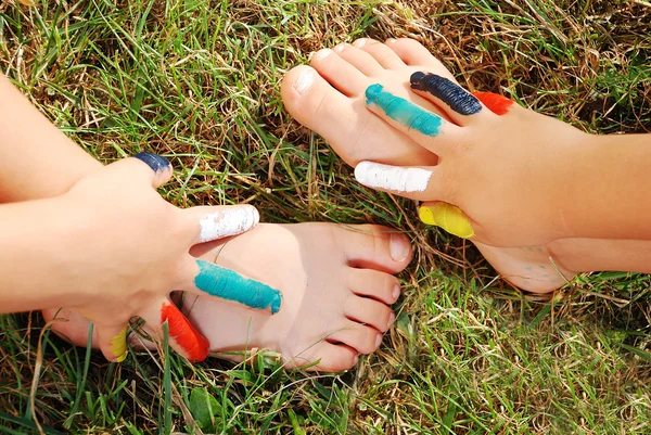 Kleuren op kind hand en hand op de been — Stockfoto