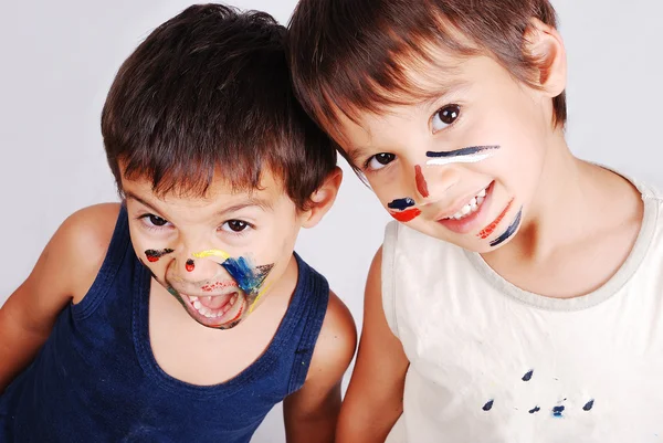 Two little cute brothers with colors on their faces — Zdjęcie stockowe