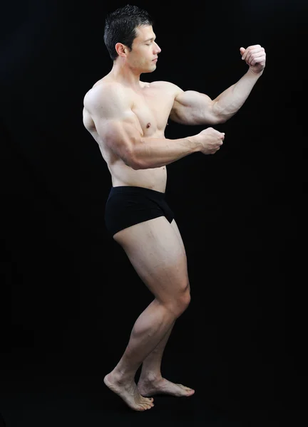 Den perfekta manliga kroppen - awesome bodybuilder poserar Royaltyfria Stockfoton