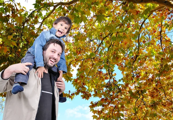 Šťastný otec a jeho syn na zádech, podzim Royalty Free Stock Fotografie