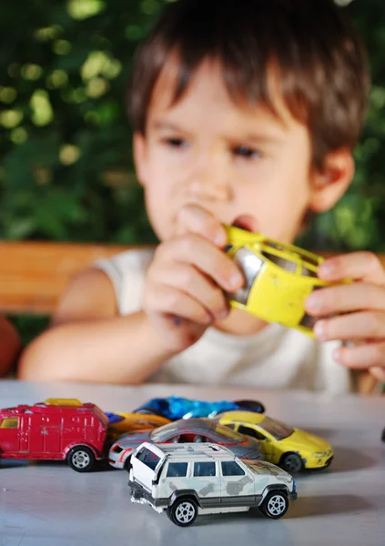 Niños jugando con coches juguetes al aire libre en verano Fotos De Stock