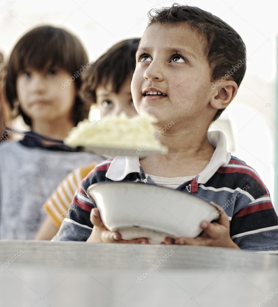 Refugee camp, poverty, hungry children receiving humanitarian food