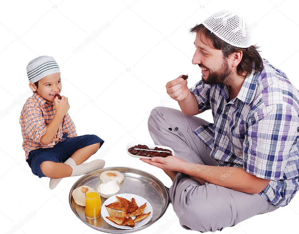 Young muslim man and his son with prepared food for iftar in Ramadan