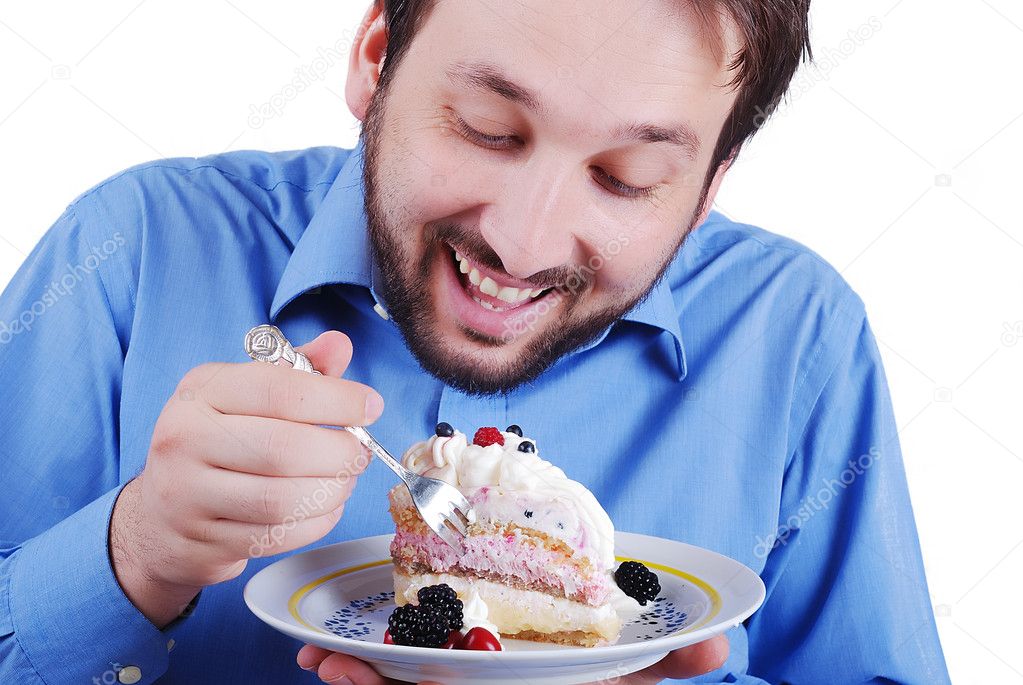 Young man eating colorful cake, isolated